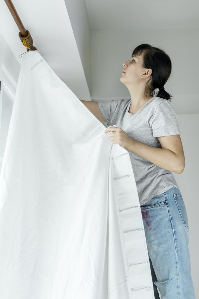 People installing window curtain