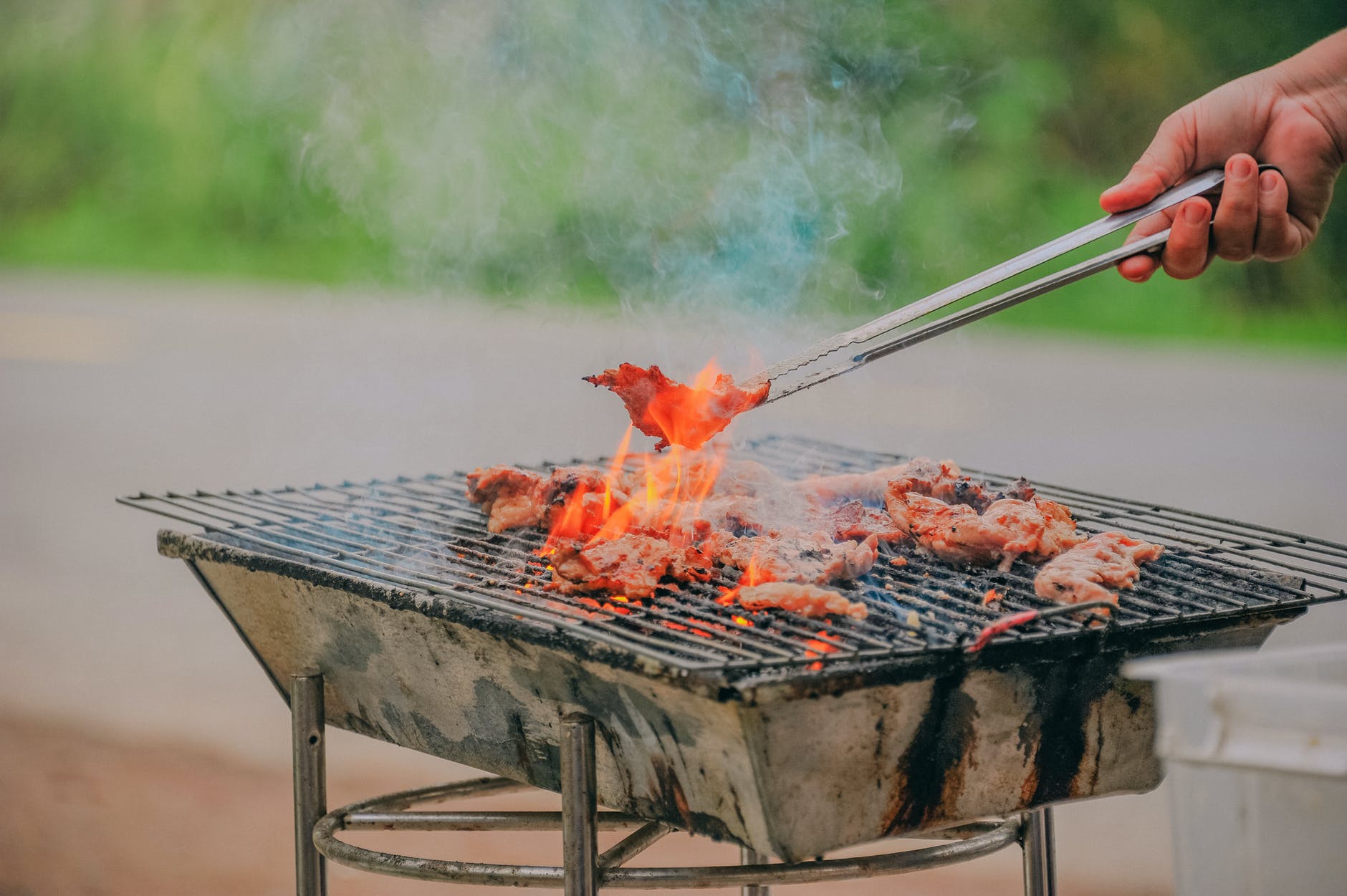 person holding tongs ccoking barbecue