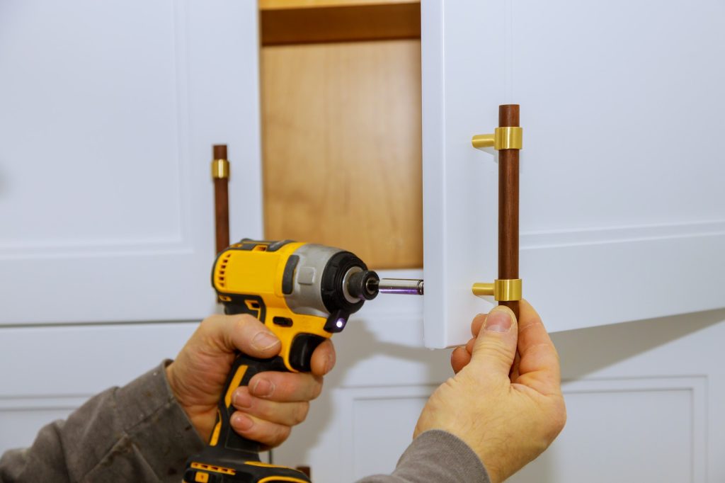 Installation of furniture hinges on the cabinet door master drills the door in the cabinet door